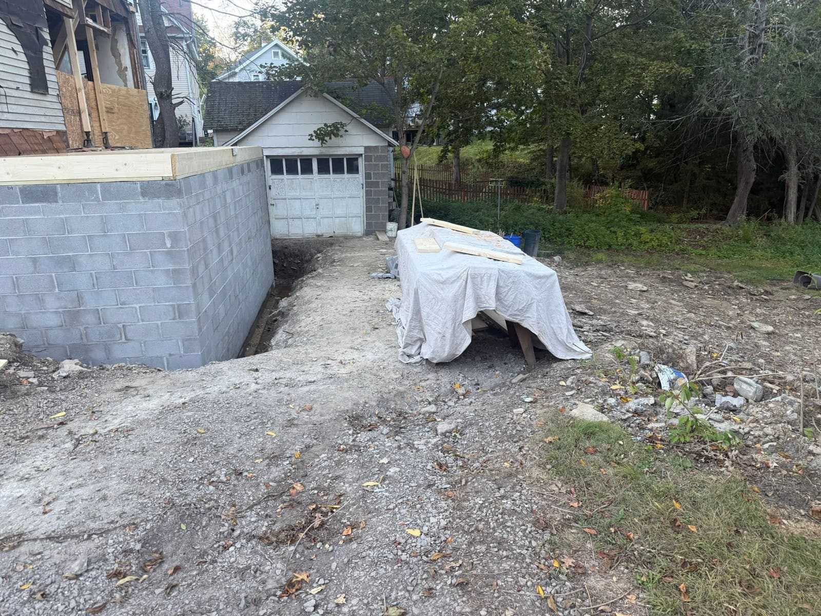 Excavation and site preparation work beside a garage foundation