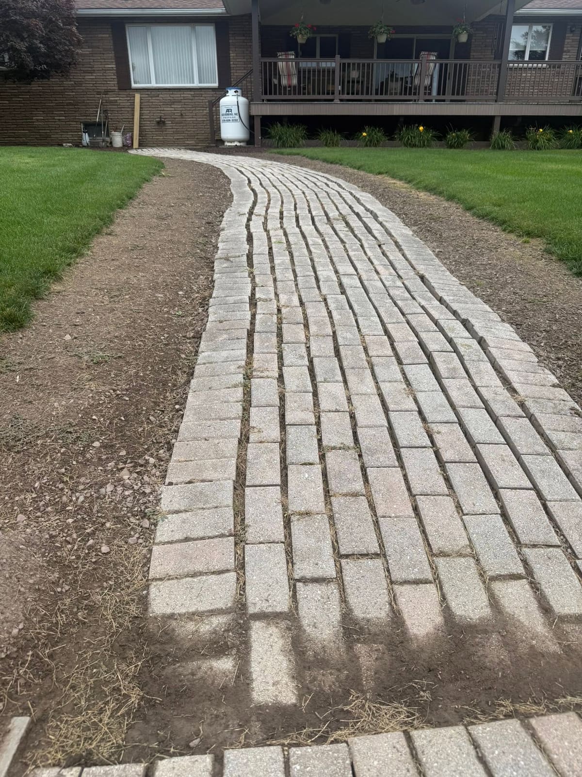 Straight paver walkway across a green lawn
